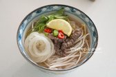 삶은 면 위에 숙주와 소고기를 푸짐하게 올립니다. 고수, 양파절임, 레몬, 고추를 곁들여 마무리합니다.