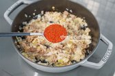 노릇하게 볶아지면 간 마늘 1 큰술, 꽃소금 ½ 작은술을 넣고 가볍게 섞습니다. 이어 고춧가루 1½ 큰술과 황설탕 1 작은술을 넣으며, 고춧가루는 굵은 것과 고운 것을 섞어 사용합니다.