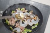 대파를 볶아 향을 낸 뒤 돼지고기를 넣고 볶습니다. 돼지고기 겉면이 익으면 새우와 맛술을 넣고 함께 볶아줍니다.