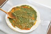 바질페스토 1 큰 술을 또띠아 위에 펴 바르며, 입맛에 따라 양을 조절합니다.