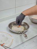 기름을 두른 예열된 팬에 반죽을 넣고, 반 이상 투명해지면 홍고추를 고명으로 올립니다.
