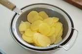 감자는 껍질을 깎고 얇고 일정한 두께로 슬라이스합니다. 물에 헹궈 전분기를 제거한 뒤 체에 밭쳐 물기를 제거합니다.
