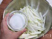 채 썬 무에 설탕과 천일염 1/2큰술을 넣고 골고루 버무립니다.