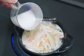 육수가 끓어오르면 홍게살과 팽이버섯을 넣어 줍니다. 재료가 2/3 정도 익으면 전분물을 조금씩 부어가며 농도를 조절하여 줍니다.