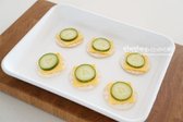 담백한 크래커를 준비하고 네모난 체더치즈는 4등분으로 잘라 올려줍니다. 그 위로 오이를 올려줍니다.