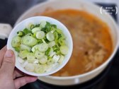 참치액, 다진 마늘, 고춧가루, 대파의 절반 분량을 넣어 더 끓입니다.