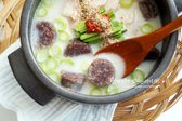 데운 순대와 고기를 그릇에 담고 뜨거운 국물을 부은 뒤, 부추, 대파, 들깨가루를 곁들여 완성합니다.