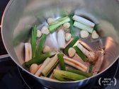 냄비에 대파와 통마늘을 넣고 갈색이 날 때까지 구워 풍미를 더합니다.