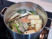 구운 대파와 마늘이 든 냄비에 물, 된장, 진간장, 맛술을 넣고 섞은 뒤 사과, 양파, 생강, 통후추, 월계수잎을 추가해 끓입니다.